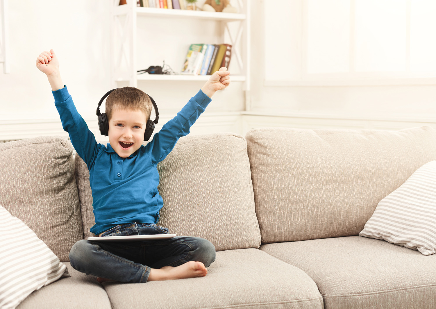 Little boy using tablet with headphones